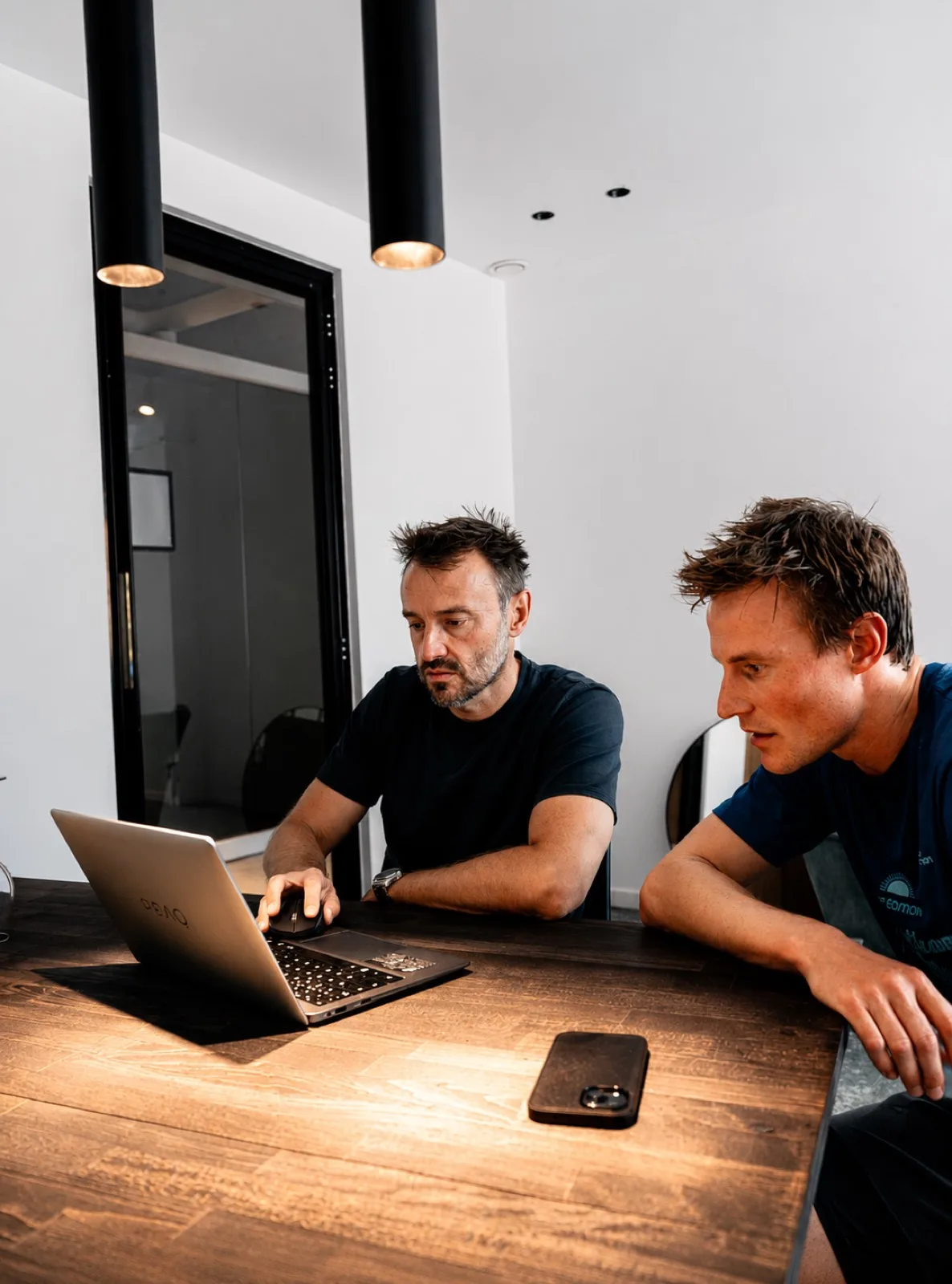 Marc Fassaert overloopt de resultaten met een atleet aan de laptop